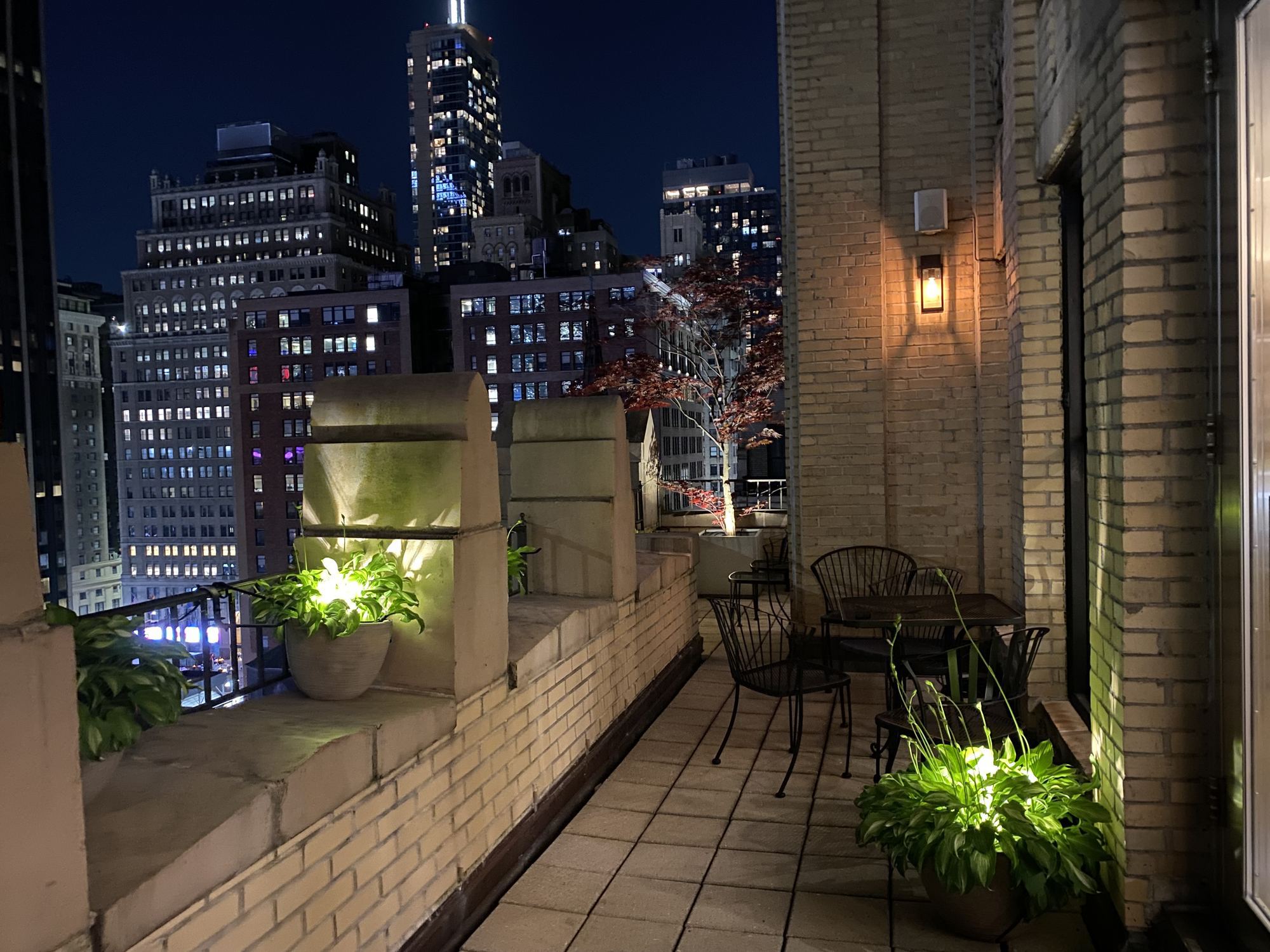 Roof deck terrace at night with Manhattan skyline